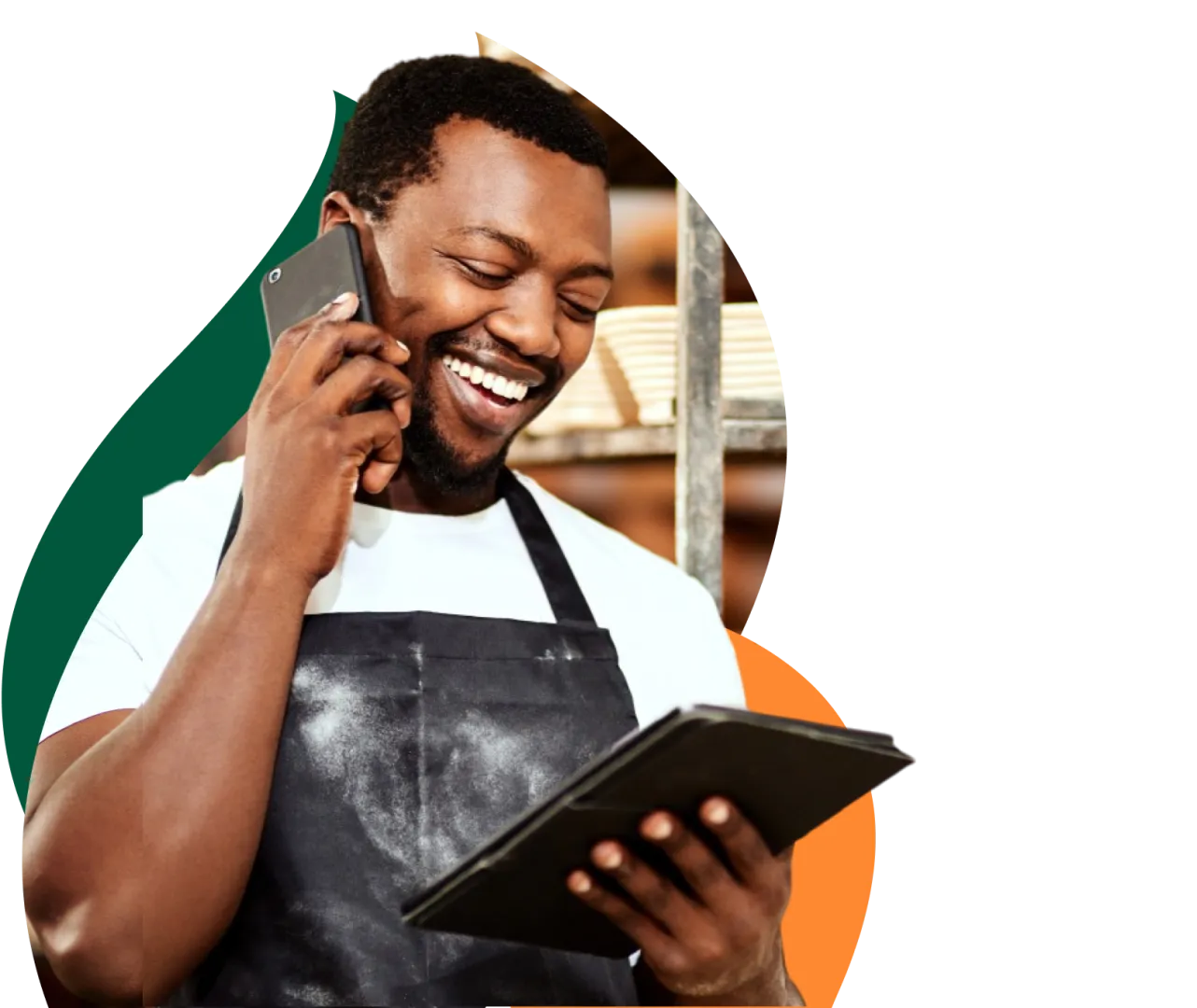 Empresário sorridente falando ao celular enquanto segura um tablet.