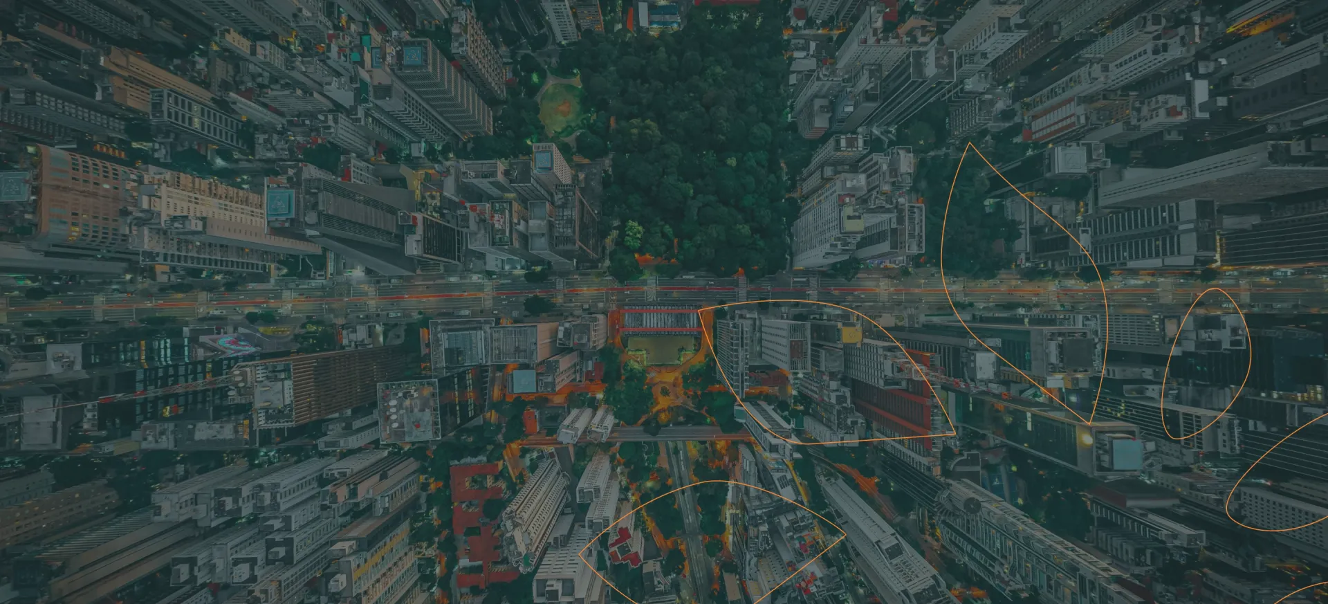 Vista aérea urbana com prédios, árvores e uma avenida cruzando a imagem. Na imagem, especificamente a Avenida Paulista, em São Paulo